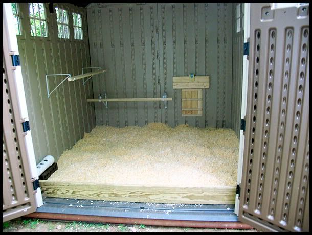 the inside of a storage shed with lots of sand in it and some doors open