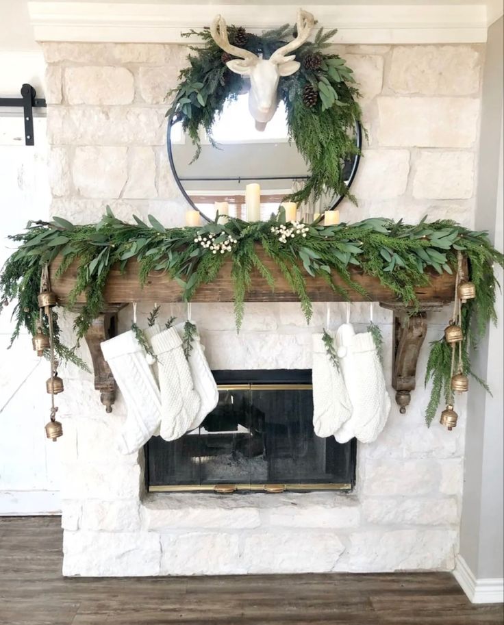 a fireplace decorated with greenery and stockings