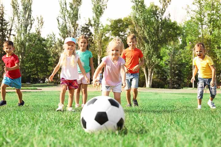 group of children playing soccer in the park