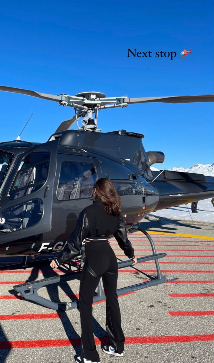 a woman in a wet suit getting out of a helicopter