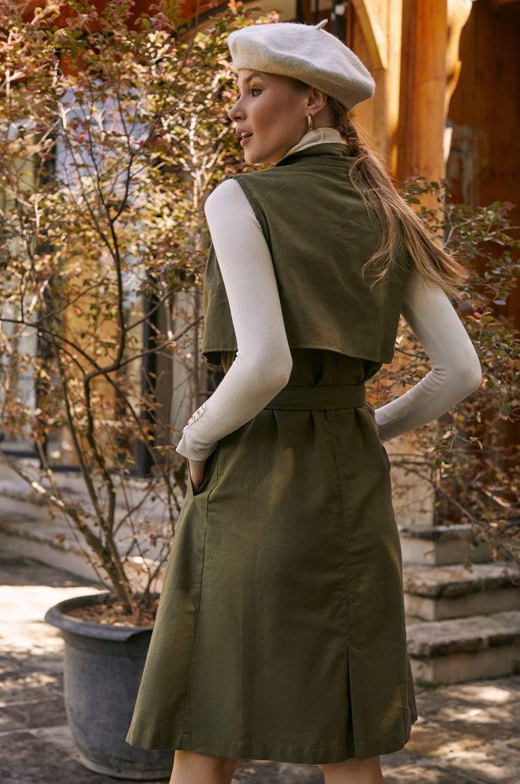 This stylish belted trench has been accented with large tortoise buttons, a matching fabric belt, and an elegant lapel-collar. Designed in a sleeveless midi silhouette it's easy to style with a camisole, blouse, or fitted turtleneck. Content: 100% Linen Hand wash warm Button-down style Belted Unlined Length: S = 119 cm (46.5") M = 122 cm (47.5") L = 125 cm (49") XL = 128 cm (50") 2XL = 130 cm (50.5") 3XL = 132 cm (51.5") Spring Outerwear With Self Belt, Fall Collared Belted Dress With Belted Cuffs, Elegant Belted Outerwear For Day Out, Chic Spring Outerwear With Belt Detail, Chic Fall Belted Dress With Belted Cuffs, Knee-length Belted Outerwear For Work, Fall Belted Knee-length Outerwear, Knee-length Belted Fall Outerwear, Knee-length Belted Outerwear For Fall