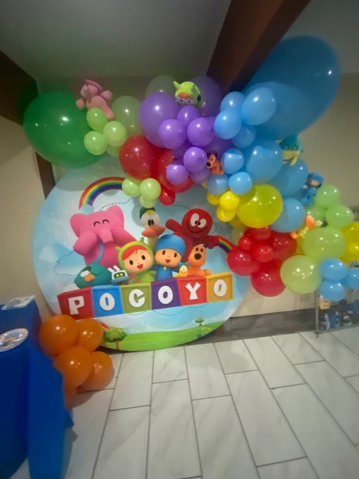 there is a bunch of balloons on the floor in front of a sign that says poco xo