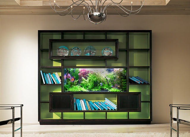 a living room filled with lots of furniture and a fish tank on top of a shelf