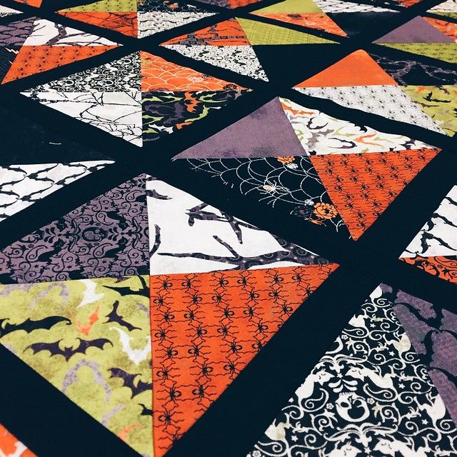 an orange and black patchwork quilt with different patterns