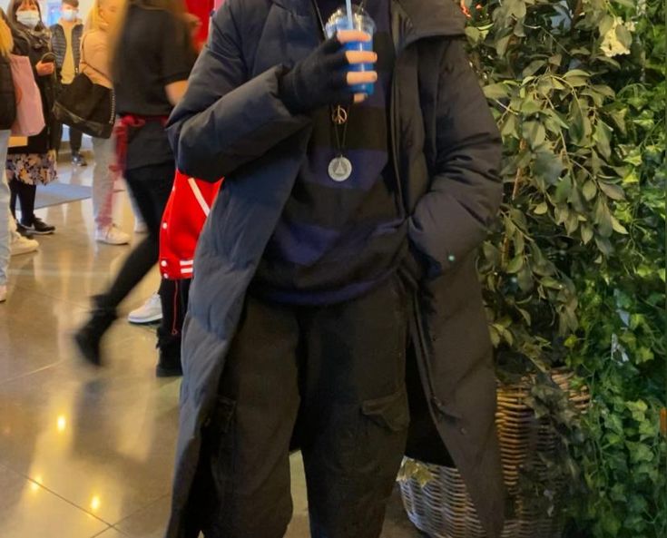 a man is standing in the middle of an indoor shopping mall with his umbrella up