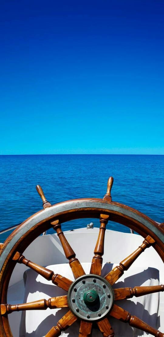 the steering wheel on a boat in the ocean