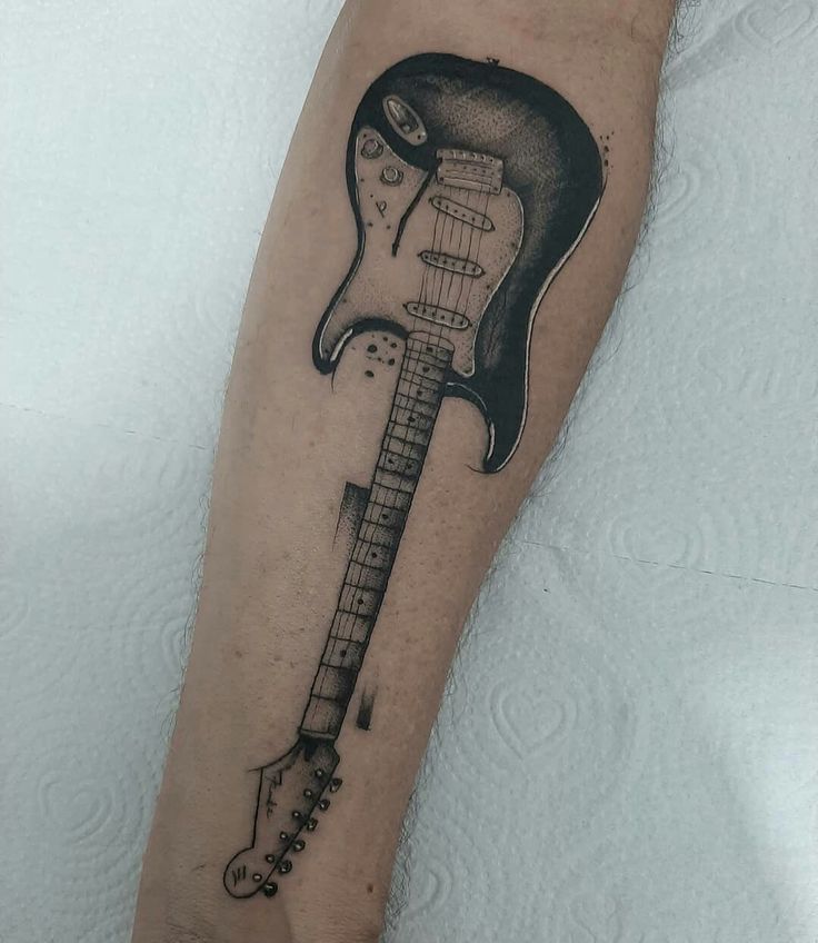 a black and white photo of a guitar tattoo