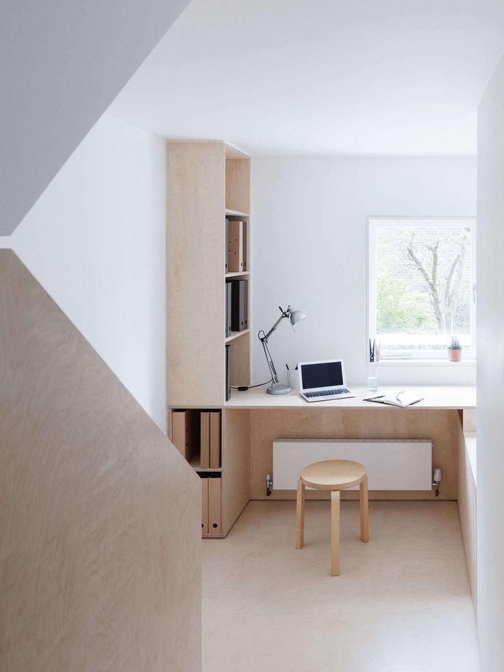 a room with a desk, bookshelf and computer on the table in it