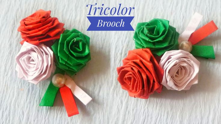 two pieces of paper flowers with ribbons attached to them