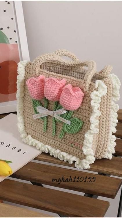 a crocheted purse with pink flowers on it