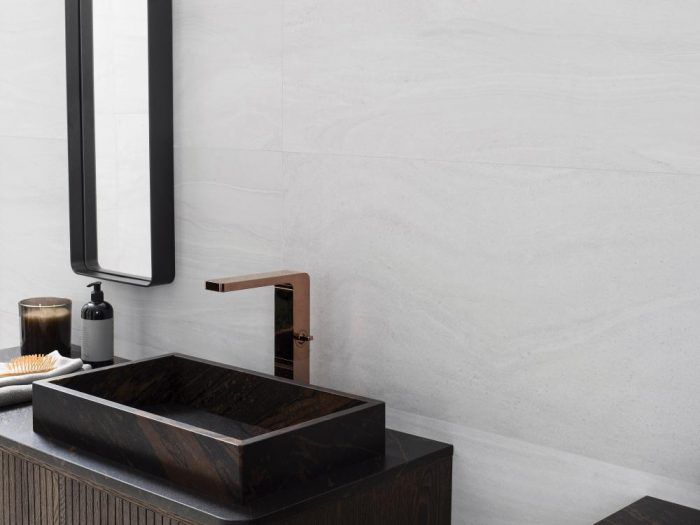 a bathroom with a sink, mirror and soap dispenser on the counter