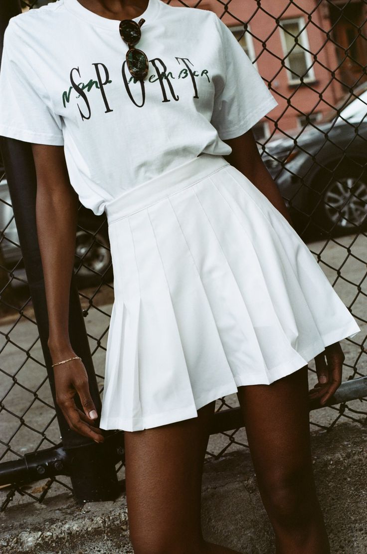 a woman wearing a white skirt and t - shirt with the word op written on it