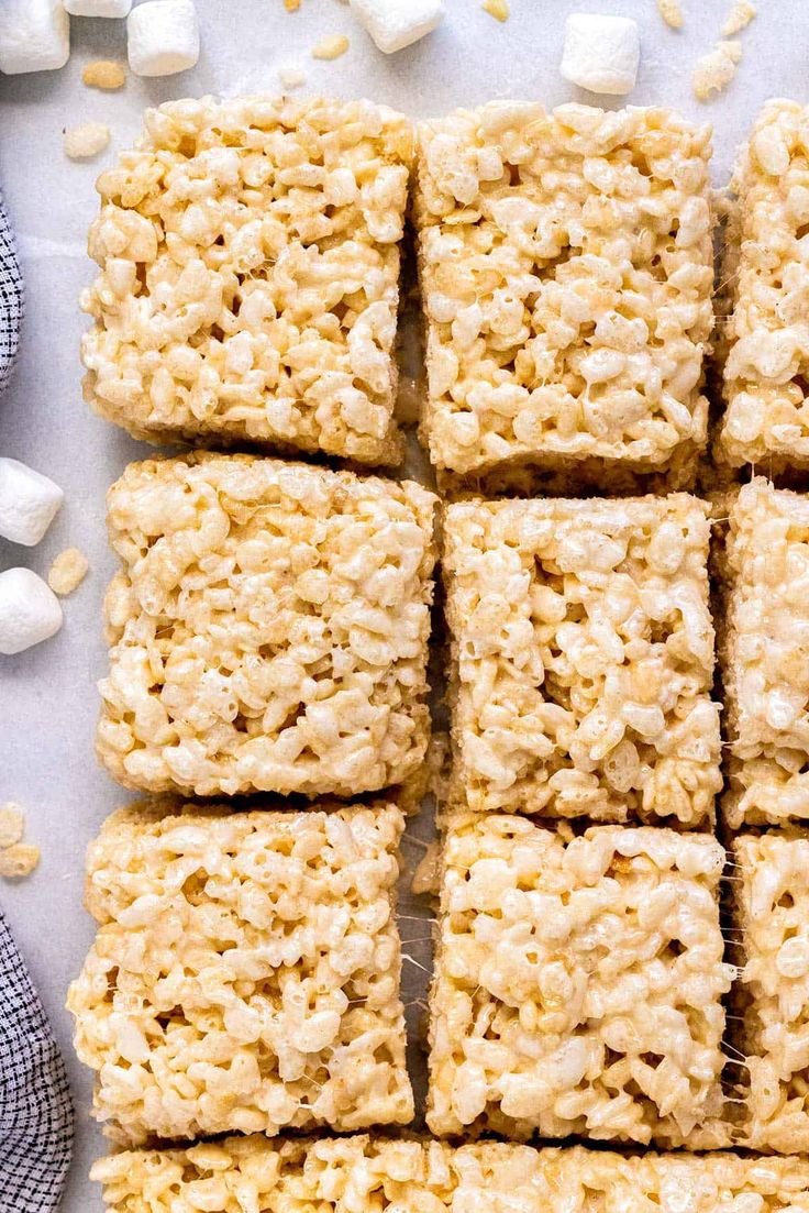 several squares of rice krispy treats next to marshmallows