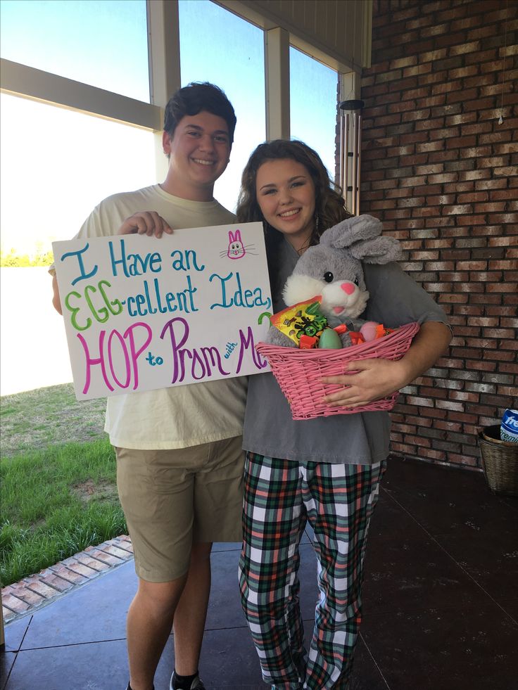 a man and woman holding a sign that says i have an excellent little hop from mom