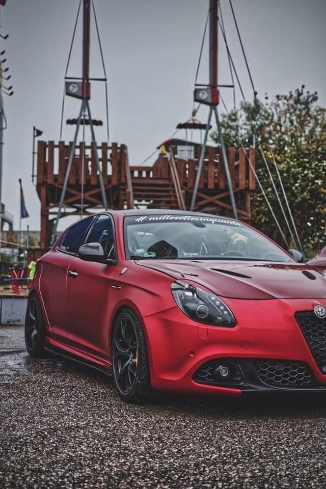 a red sports car parked in front of an amusement park