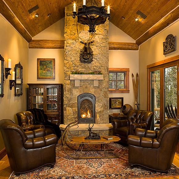 a living room with leather furniture and a stone fireplace