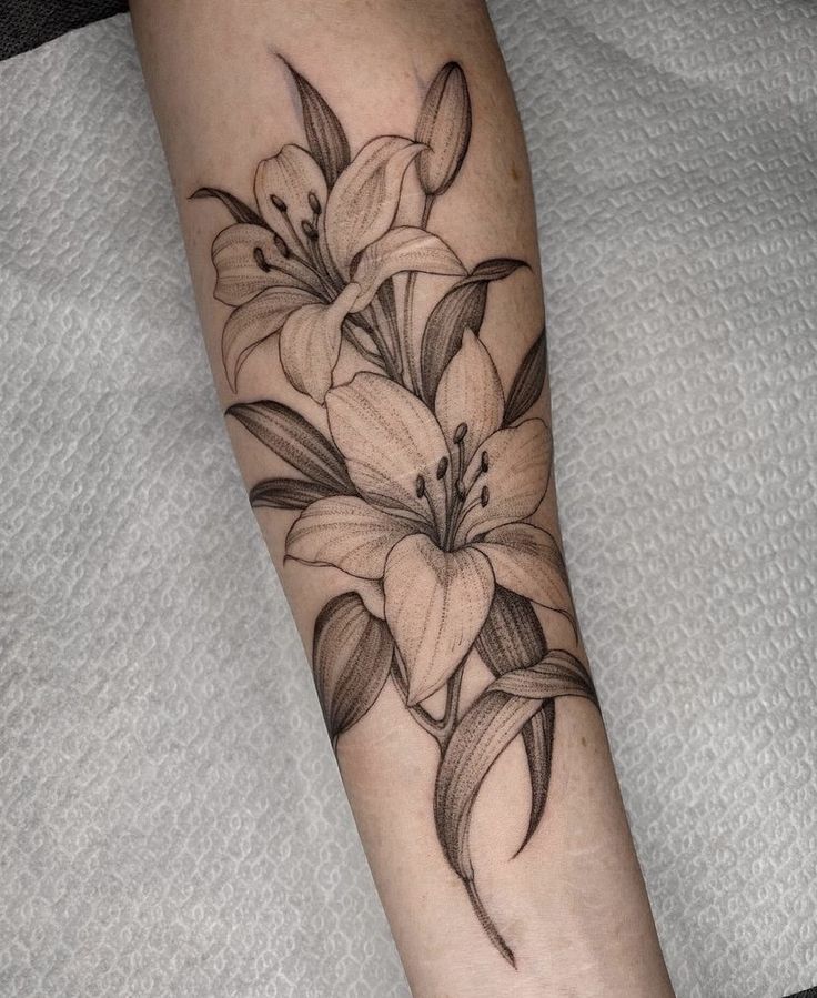 a black and white flower tattoo on the arm