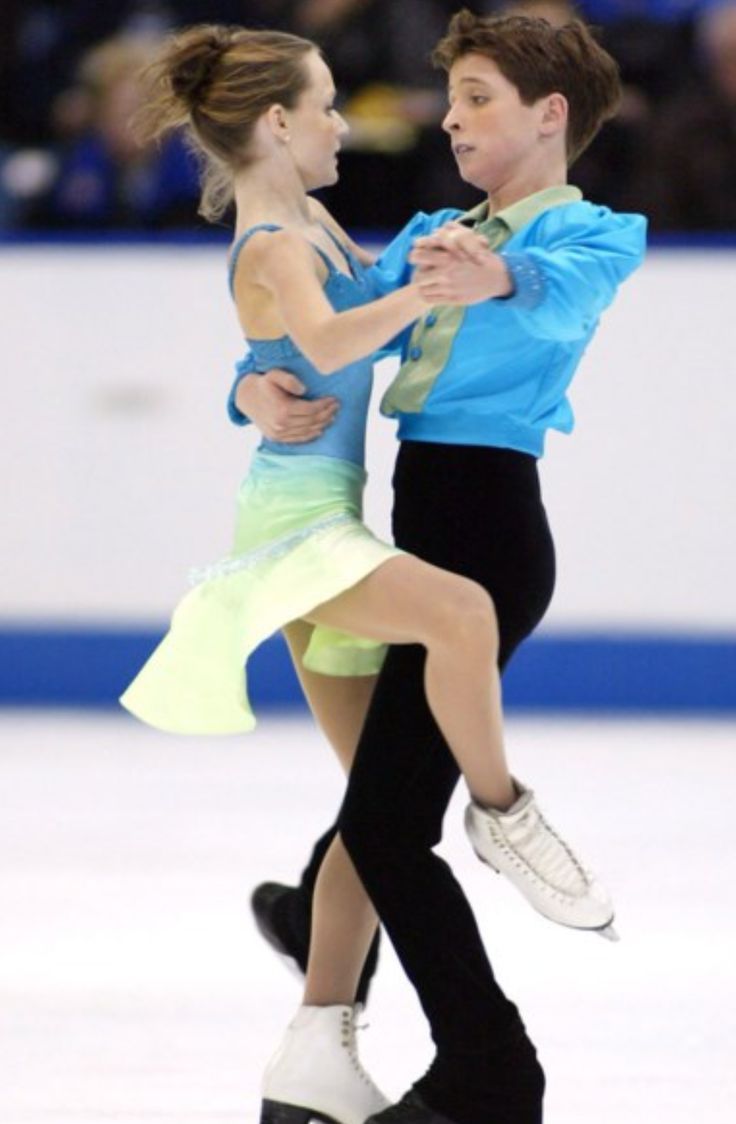 two people skating on an ice rink with one holding the other's leg up