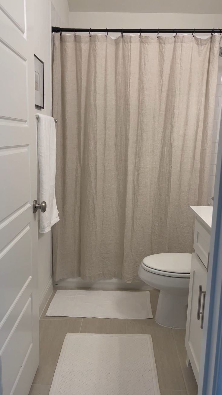 a white toilet sitting next to a shower curtain