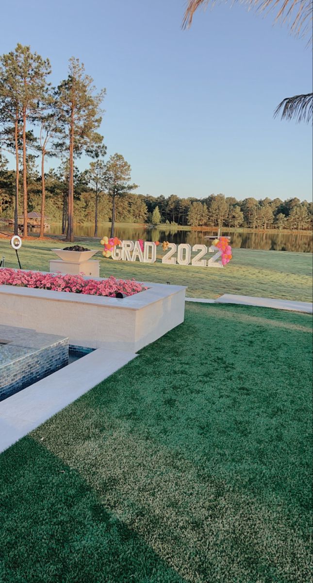 an outdoor garden with grass and flowers on the ground in front of a sign that says grandad 2012