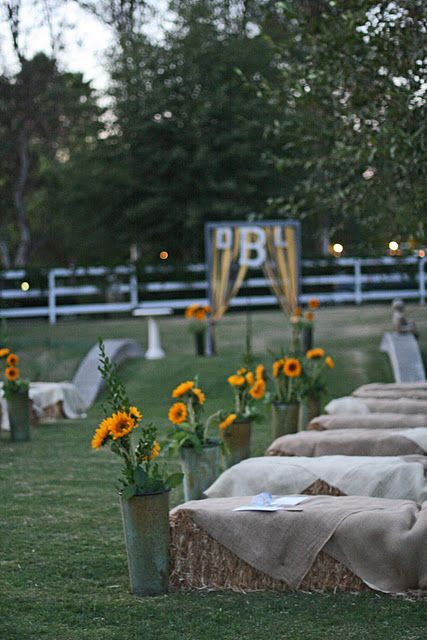 an outdoor wedding setup with sunflowers in vases