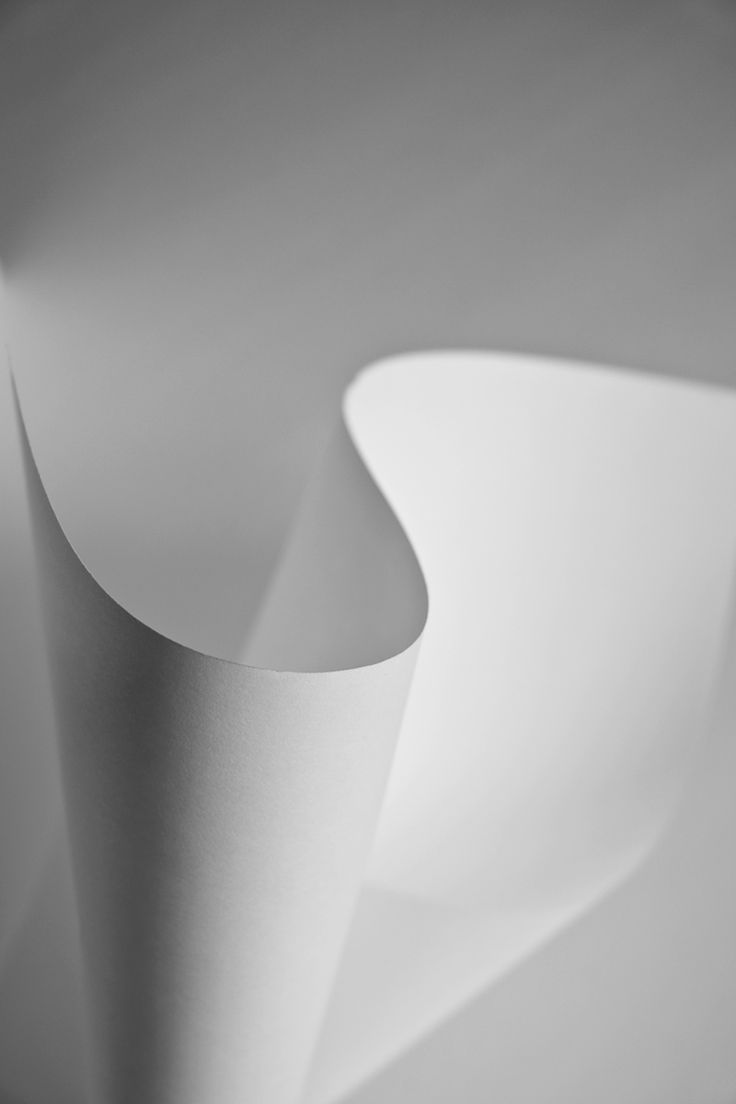 an abstract photo of white paper folded in two different directions, with room for text on the bottom right corner