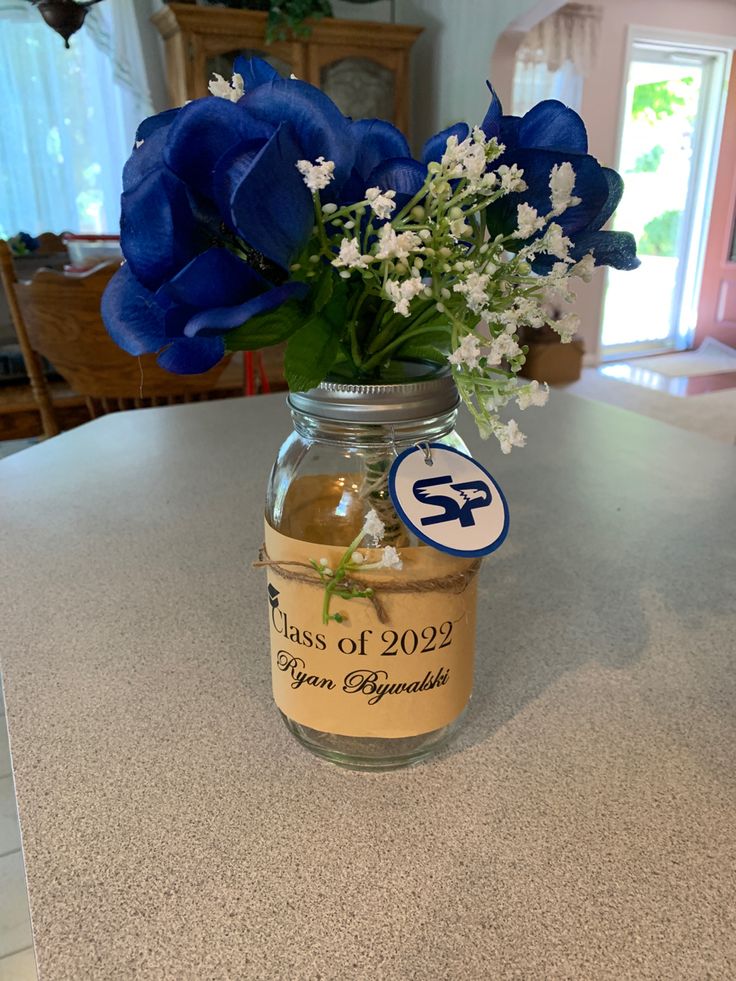 a mason jar filled with blue flowers on top of a counter