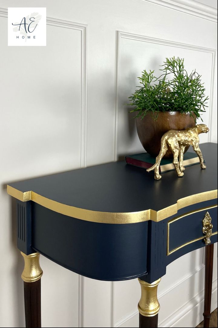 a blue and gold console table with a potted plant sitting on top of it