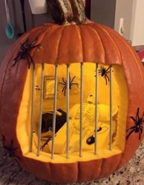 a pumpkin shaped caged in with halloween decorations