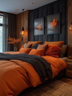 a bed with orange sheets and pillows in a bedroom next to a large glass window