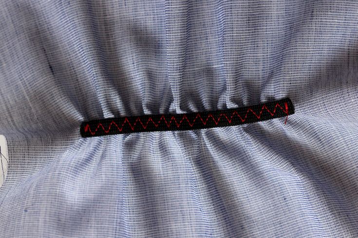 a close up view of a blue shirt with a red ribbon on it's lapel