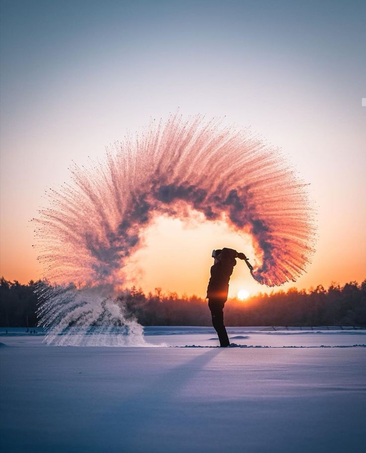 a person standing in the snow with their arms spread out