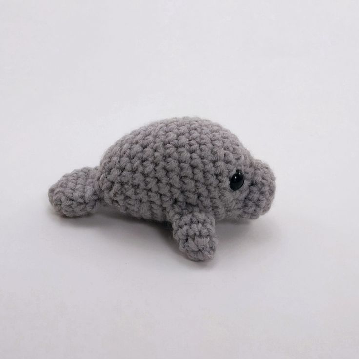 a crocheted stuffed animal laying on top of a white surface