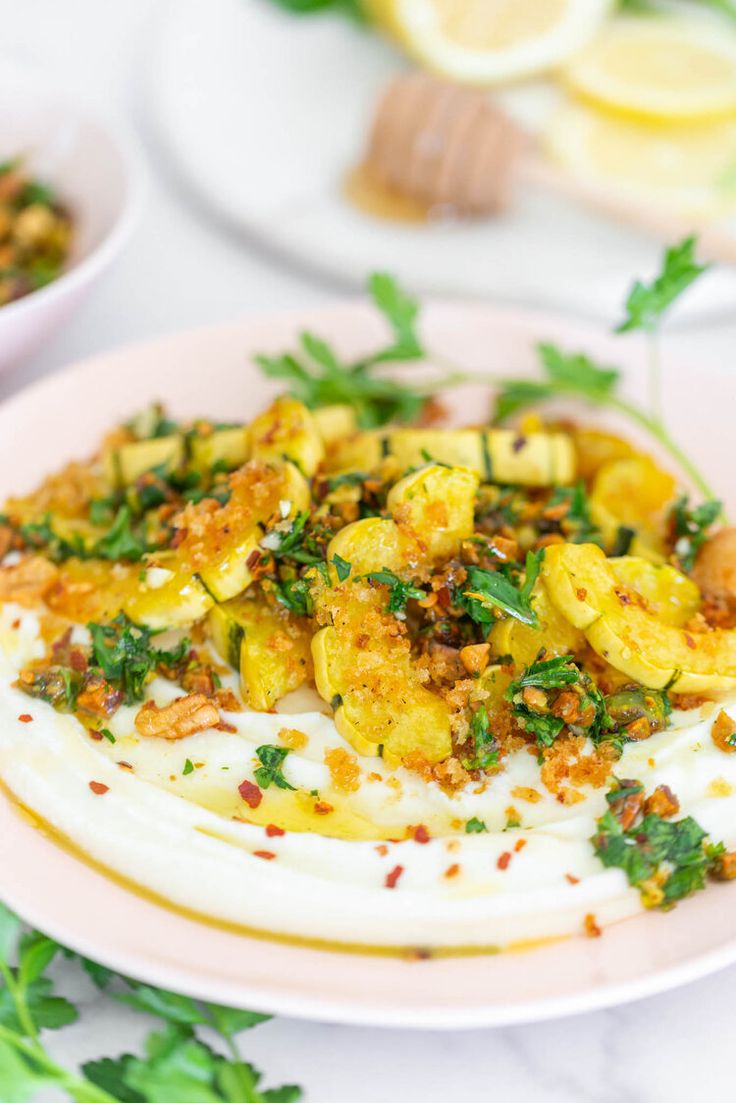 a white plate topped with food next to two bowls filled with lemons and parsley