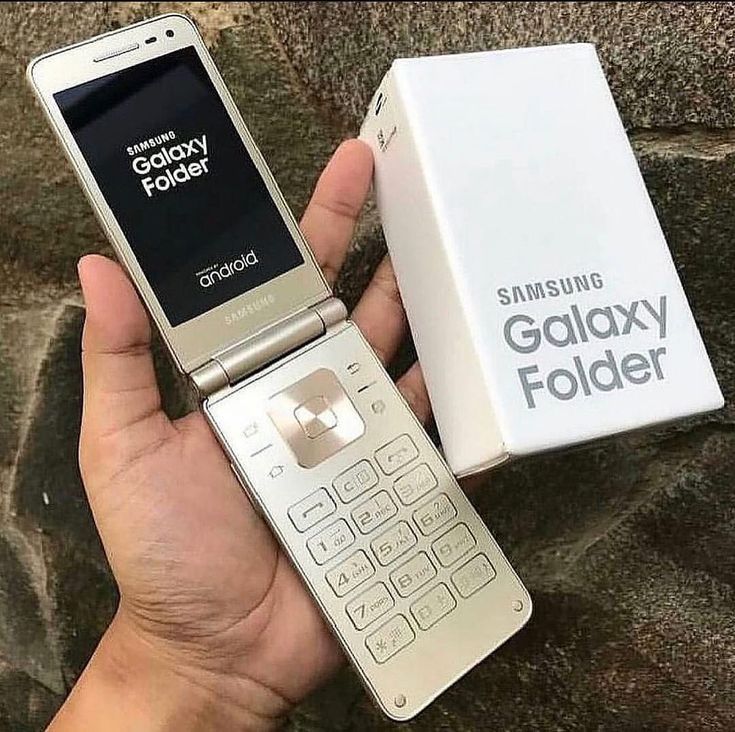 a person holding a samsung galaxy fold phone in their hand next to an open box