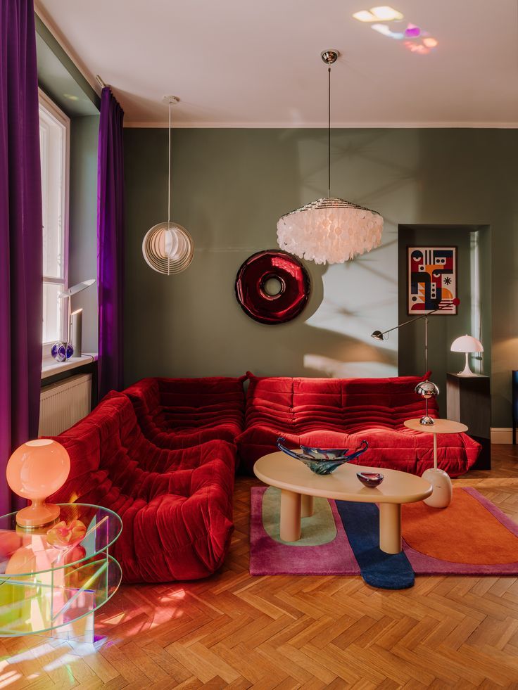 a living room filled with red couches and colorful rugs