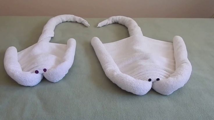 two white stuffed animals laying on top of a bed