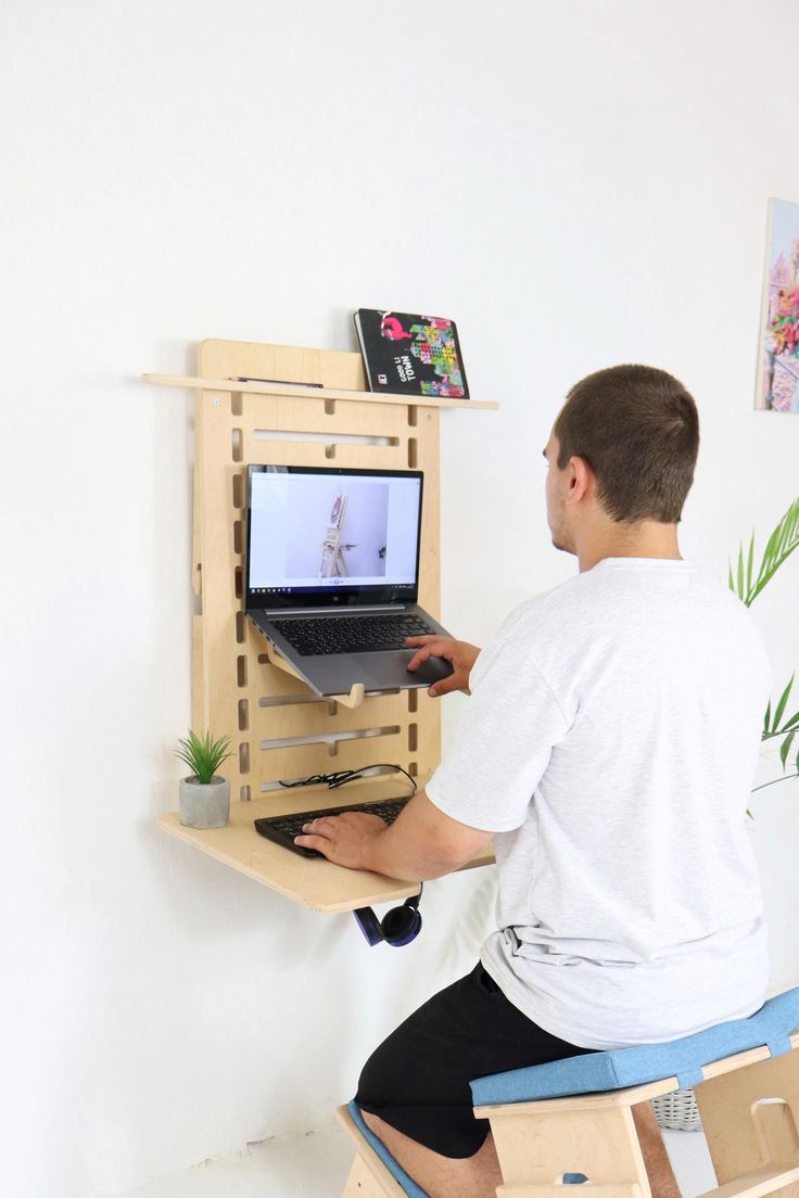 a man sitting at a desk using a laptop computer