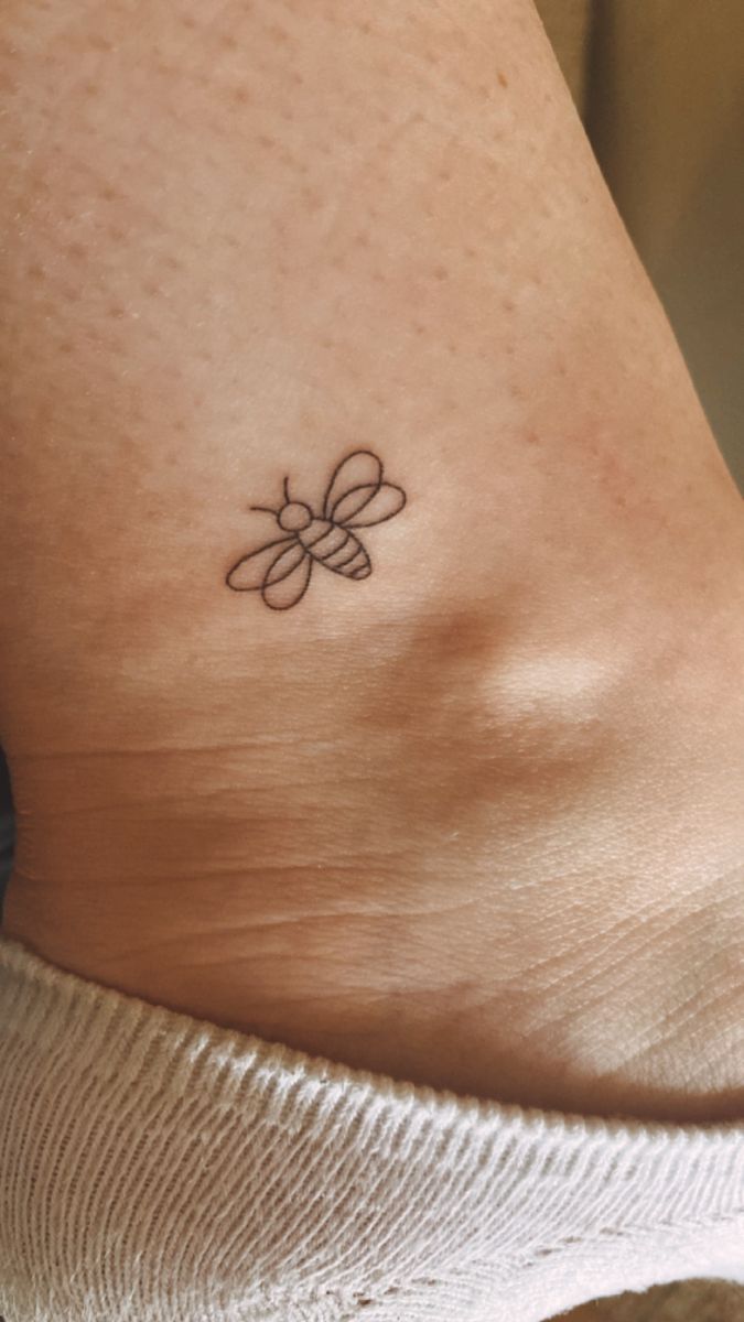 a woman's foot with a small tattoo on the side of her leg,