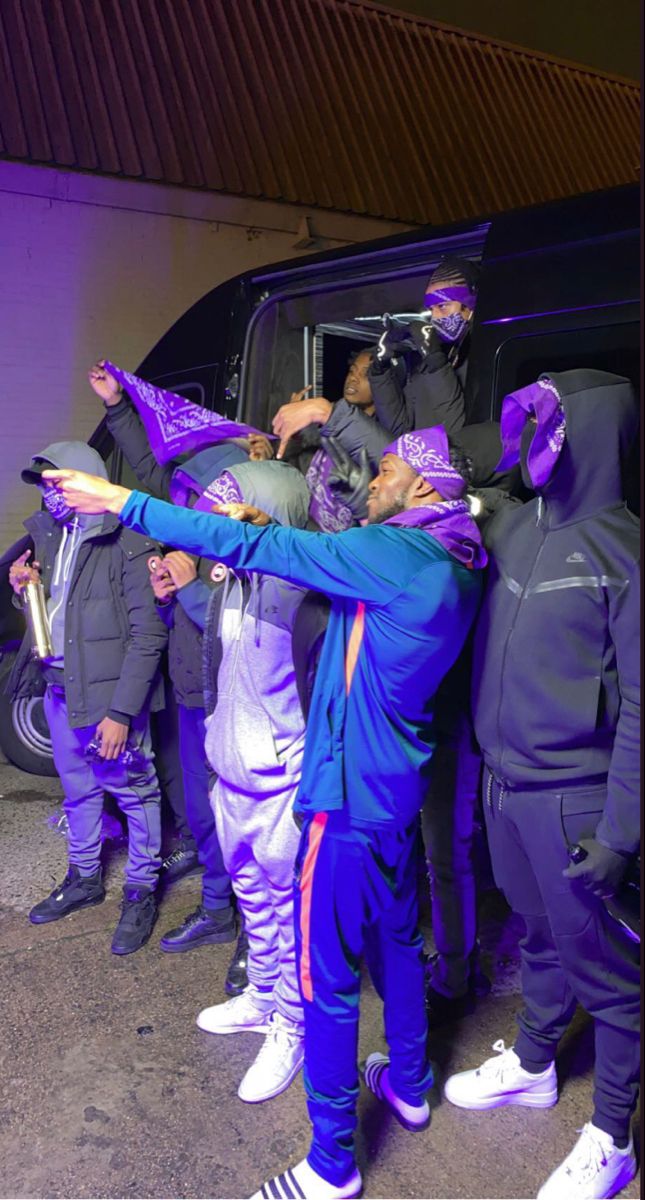 a group of people standing next to each other in front of a van with purple paint on it