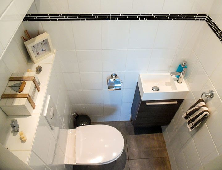 an aerial view of a bathroom with toilet, sink and shower head mounted on the wall