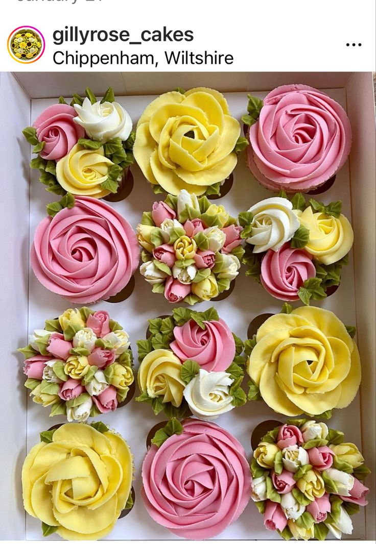 cupcakes in a box decorated with pink, yellow and white frosting flowers