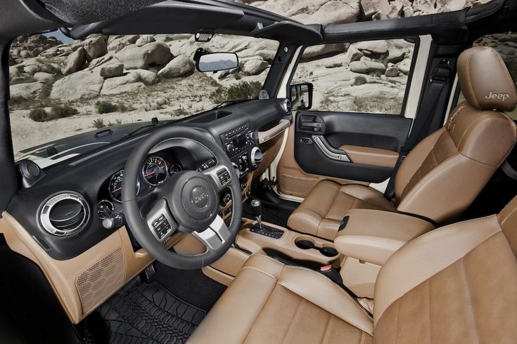 the interior of a vehicle with tan leather and black trims is shown in front of some rocks