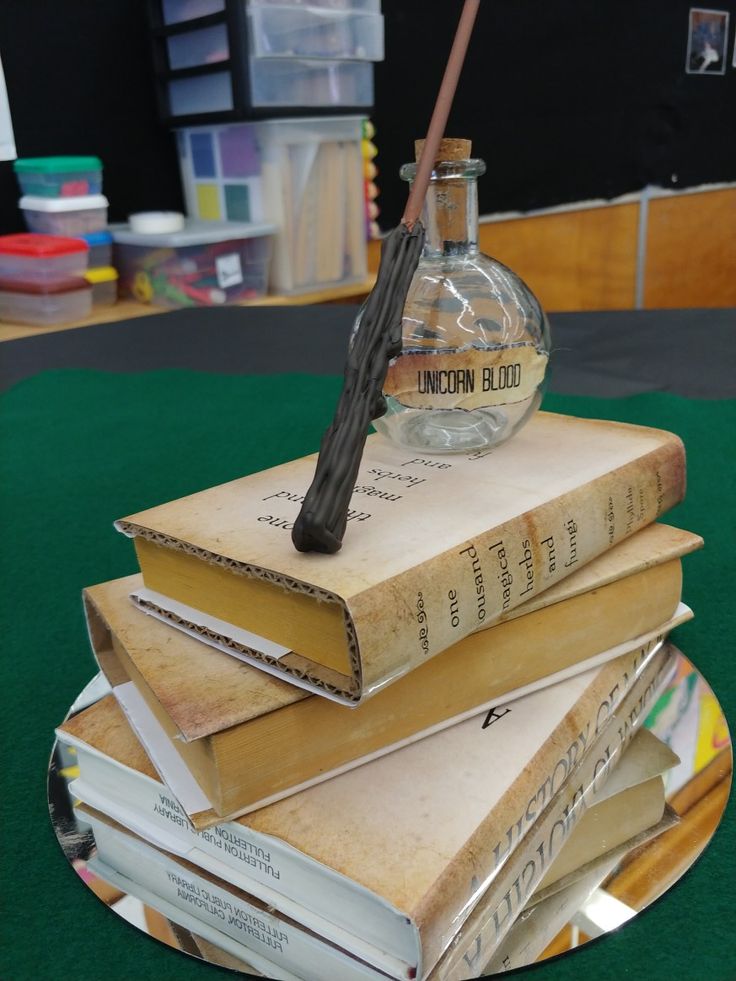 a stack of books sitting on top of each other next to a bottle filled with an ink pen