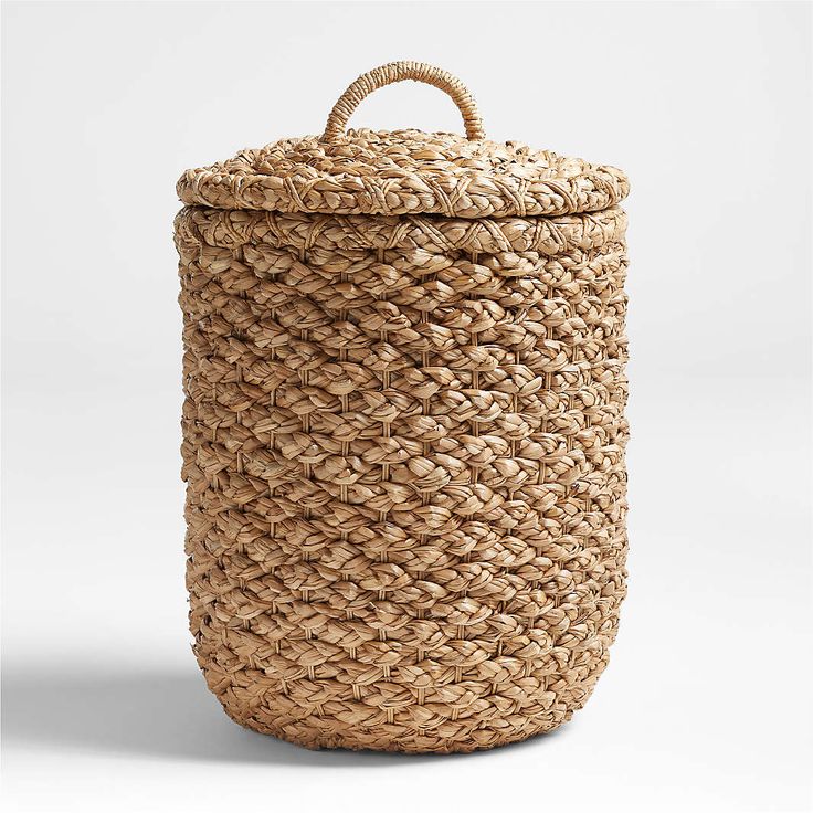 a large woven basket with handles on the top and bottom, sitting in front of a white background