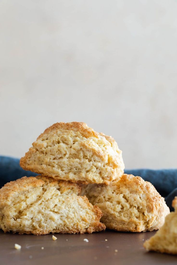 three biscuits stacked on top of each other in front of a blue cloth and white wall