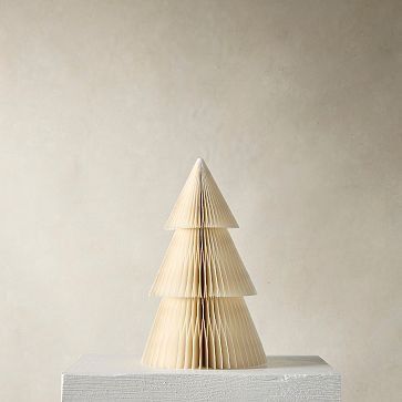 a small wooden christmas tree sitting on top of a block of white plexed wood