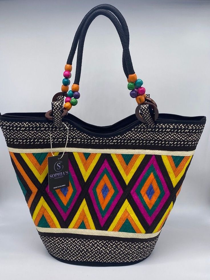 These beautiful handbags are made from Cana Flecha which is an indigenous palm fiber found in the northern territory of Colombia. They are beautifully hand crafted by the people from the Zenu tribes in Colombia. These handbags are colorful with vibrant colors, which is a pure reflection on the region and the warmness of these master artisans that work in this industry every day. Traditional Multicolor Bucket Straw Bag, Palm Leaf Bucket Bag For Market, Traditional Black Handwoven Bags, Traditional Handwoven Black Bags, Traditional Black Rectangular Crochet Bag, Traditional Rectangular Market Bag, Multicolor Rectangular Jute Shoulder Bag, Traditional Tote Bag With Braided Handles, Traditional Tote Beach Bag