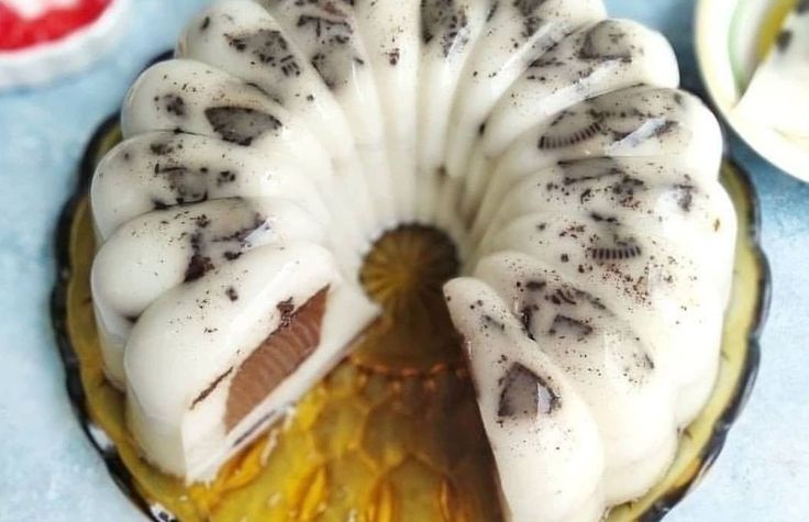 a bundt cake with white frosting and chocolate toppings