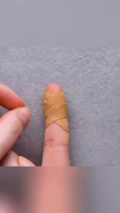 a finger is taped to the side of a piece of paper with a bandage on it